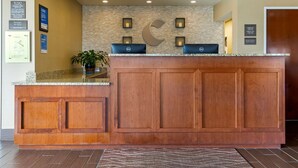 Un mostrador de recepción con detalles de madera, un fondo de pared de piedra y una decoración con forma de luna creciente.
