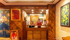 Ein Empfangsbereich mit einem Holzboden, gerahmten Porträts und einem dekorativen Altar.