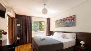 Una habitación de hotel con una cama, un escritorio y una silla.