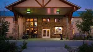 A hotel with a brick facade, a covered entrance, and a sign indicating it offers TV rental.