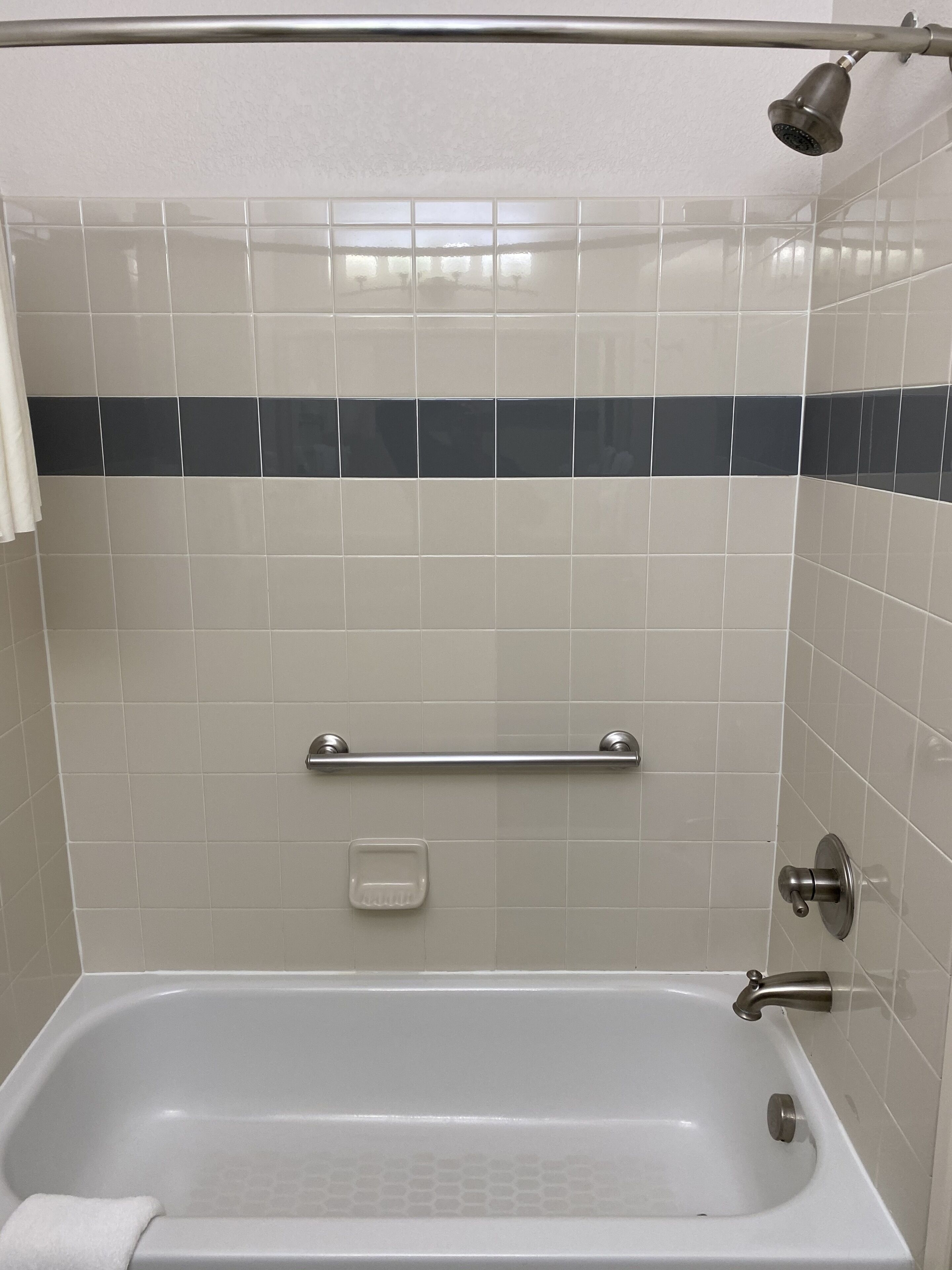 Une salle de bain équipée d’une baignoire, d’une douche et d’un porte-serviettes.