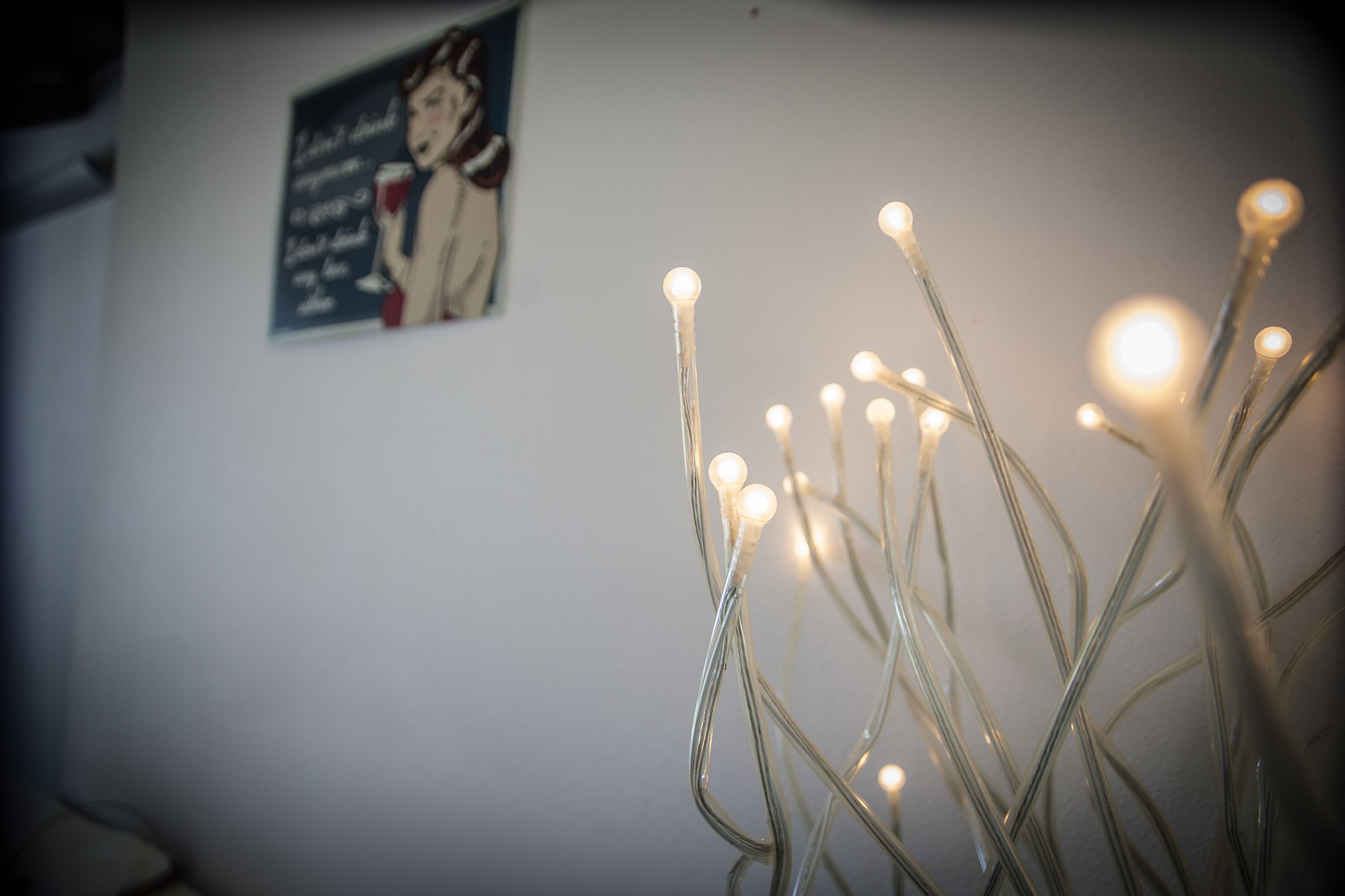 Eine Wand mit einem Poster und Lichterketten.