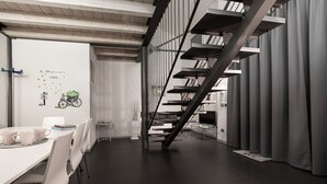Un interior moderno con una escalera, muebles blancos y una pizarra con una cita motivacional.