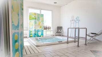 Relax by the pool with a clear view of the outdoors, featuring a hot tub and lounge chair.