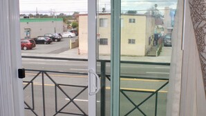 Una puerta de vidrio corrediza que da a un balcón con barandilla metálica.