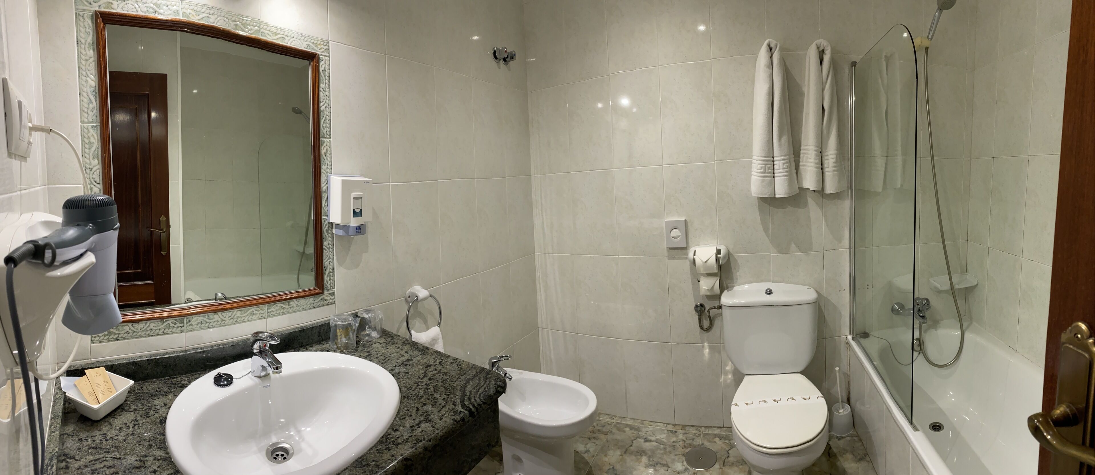 Een badkamer met wastafel, toilet en douche.