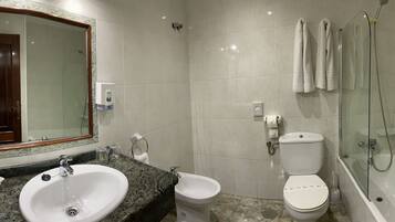 Een badkamer met wastafel, toilet en douche.
