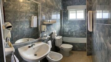 Un baño moderno con lavamanos, inodoro, bidé y bañera.