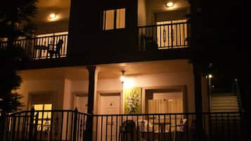 Un edificio de dos pisos con un balcón, una escalera y una puerta decorada con una pintura.
