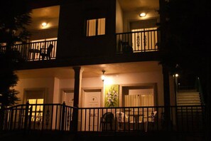 Un edificio de dos pisos con un balcón, una escalera y una puerta decorada con una pintura.