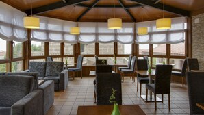 A spacious indoor area with wooden beams, large windows, and comfortable seating. - Hotel & Apartamentos Cons da Garda (O Grove)