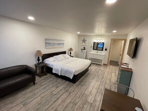 A bedroom with a bed, bedside tables, a TV, and a desk. - The Inn at Old Town (Bandon)