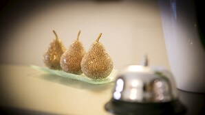 Tres peras brillantes sobre un plato de vidrio.