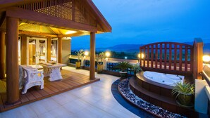 A wooden deck with a hot tub, seating area, and potted plants. - Hotel Shwe Pyi Thar (Mandalay)