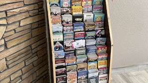 A display board with various brochures and advertisements, including a 'Luau' event and 'Tanger Outlets'. - Heritage Inn (Daytona Beach)