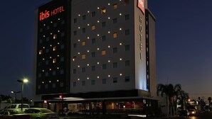 A multi-story hotel with illuminated windows and a prominent 'ibis' sign. - Ibis Los Mochis (Los Mochis)