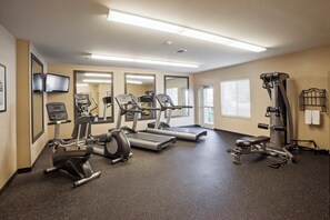Un gimnasio con cintas de correr, elípticas y máquinas de pesas.
