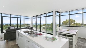 Una cocina moderna con amplios ventanales, un comedor y un sofá.