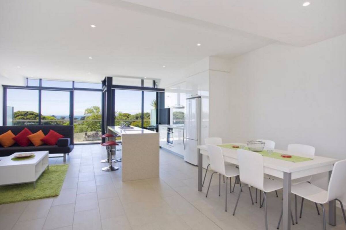 A modern, open-plan living and dining area with a large window offering a scenic view.