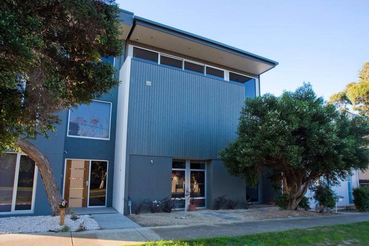 A modern building with a flat roof, large windows, and a door.