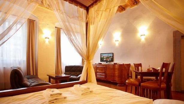 A hotel room with a bed, a desk, a chair, and a television. - Residence Muzeum Vltavinu (Cesky Krumlov)