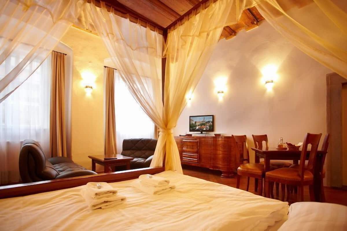 A hotel room with a bed, a desk, a chair, and a television.