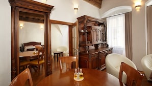 A dining area with a wooden table, chairs, and a cabinet. - Residence Muzeum Vltavinu (Cesky Krumlov)