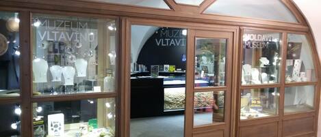 A museum with arched wooden frames and glass display cases.