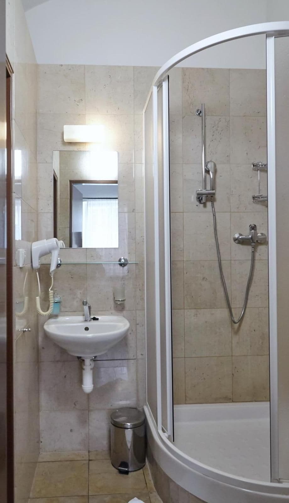 Une salle de bain avec une douche à parois de verre, un lavabo et un miroir.