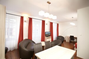 Una habitación moderna con una mesa de comedor, sillas, un televisor y un escritorio.