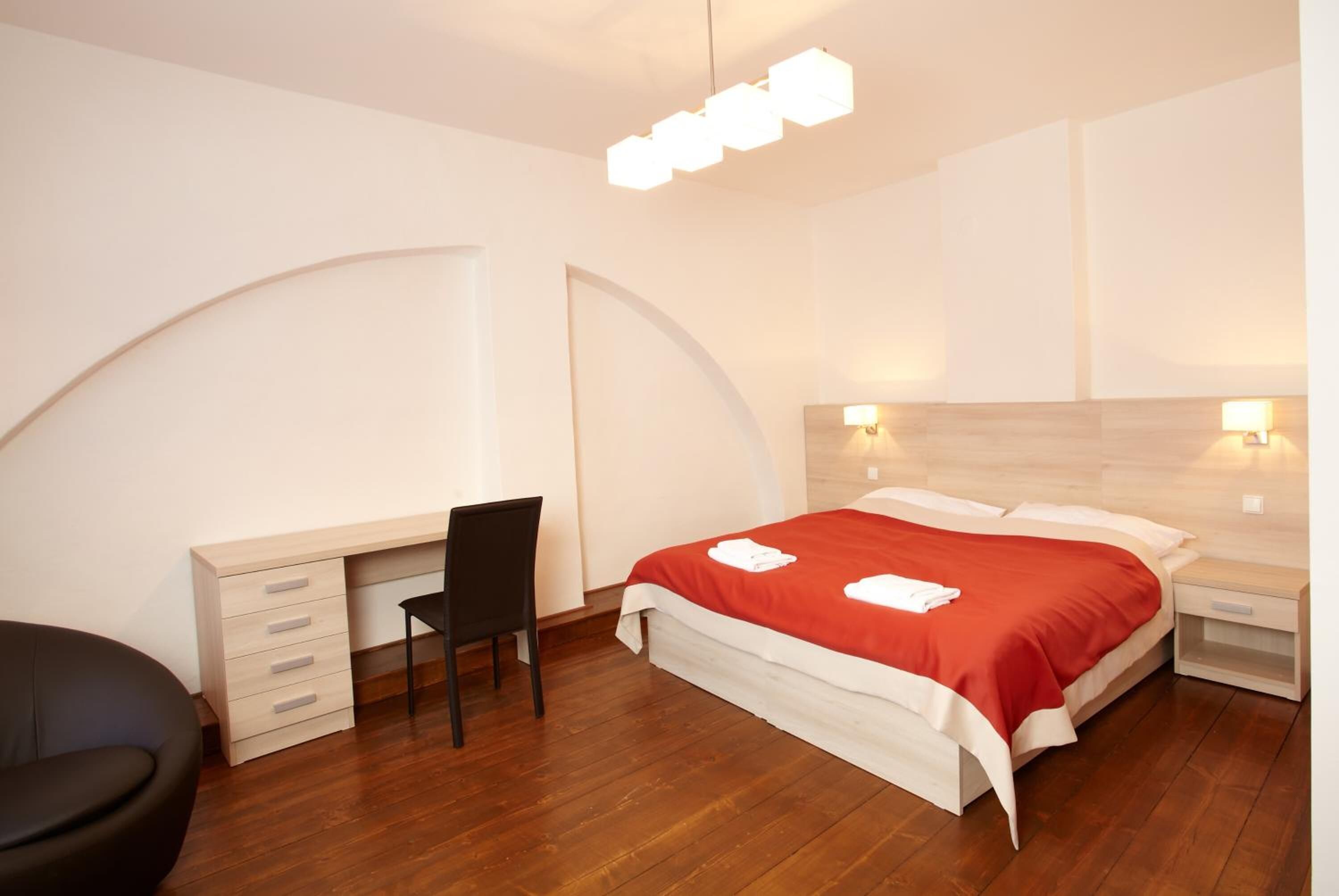 Una camera da letto con un letto, una scrivania, una sedia e comodini.