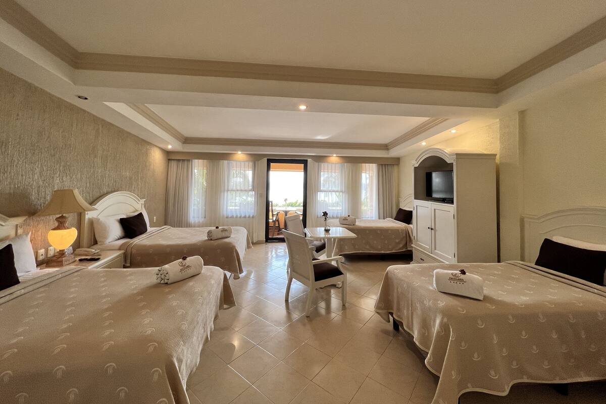 A hotel room with two beds, a TV, and a balcony.