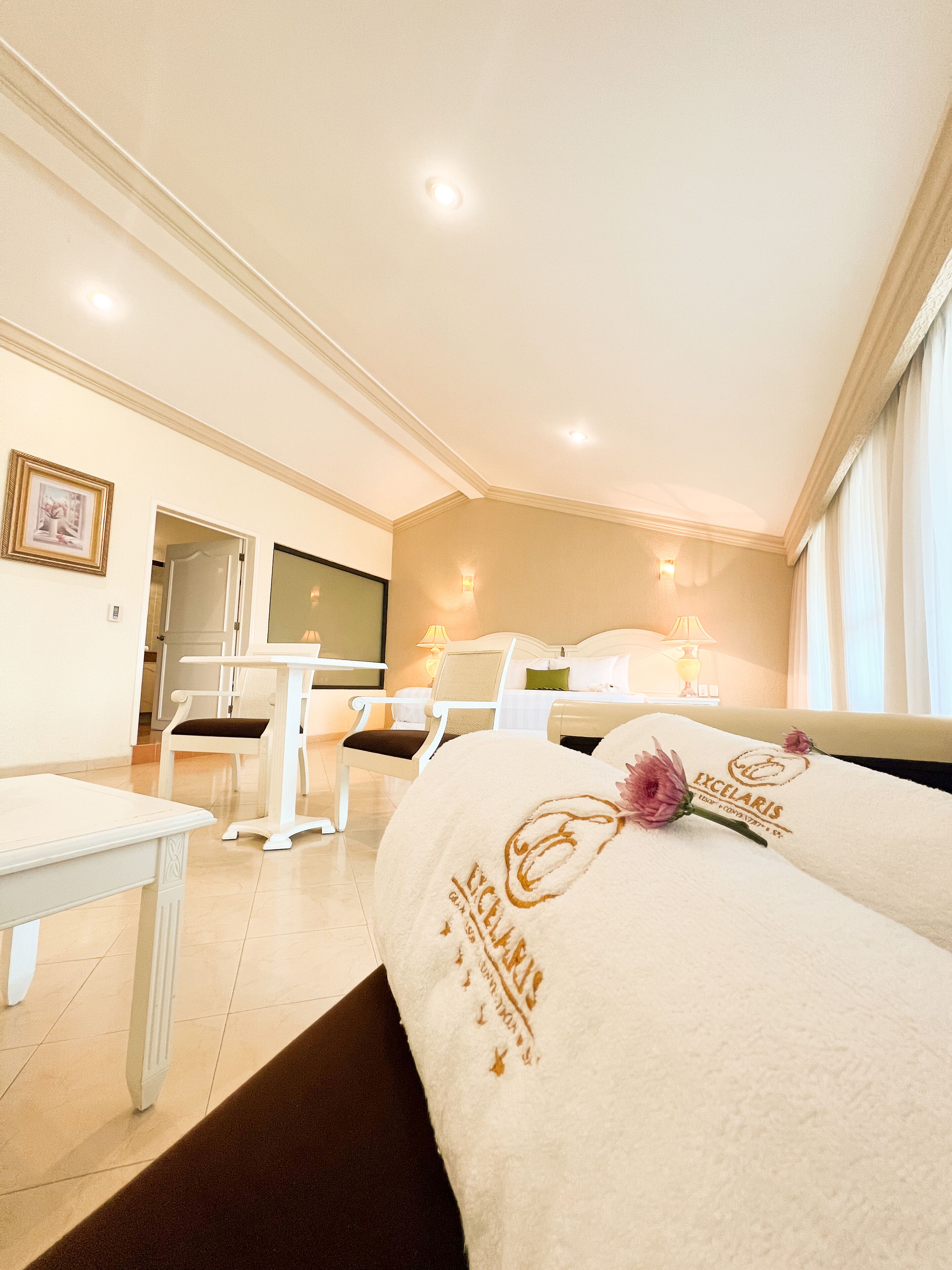 Una habitación de hotel con cama, escritorio, silla y televisor.