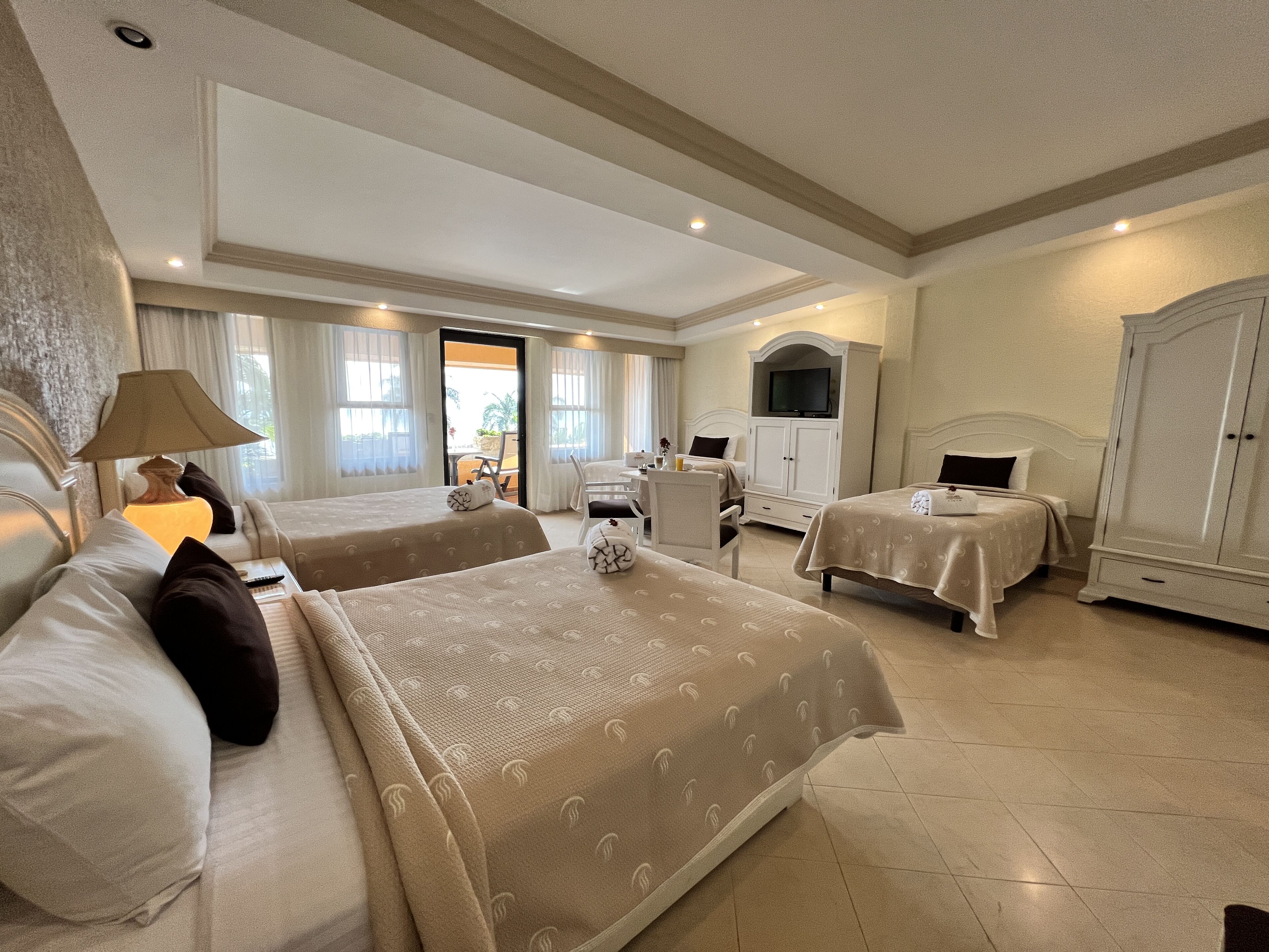 Une chambre d’hôtel avec deux lits, une télévision, un bureau et un coin repas.