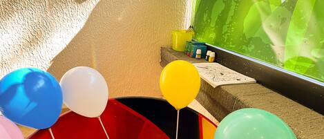 A colorful play area with a ball pit and balloons.