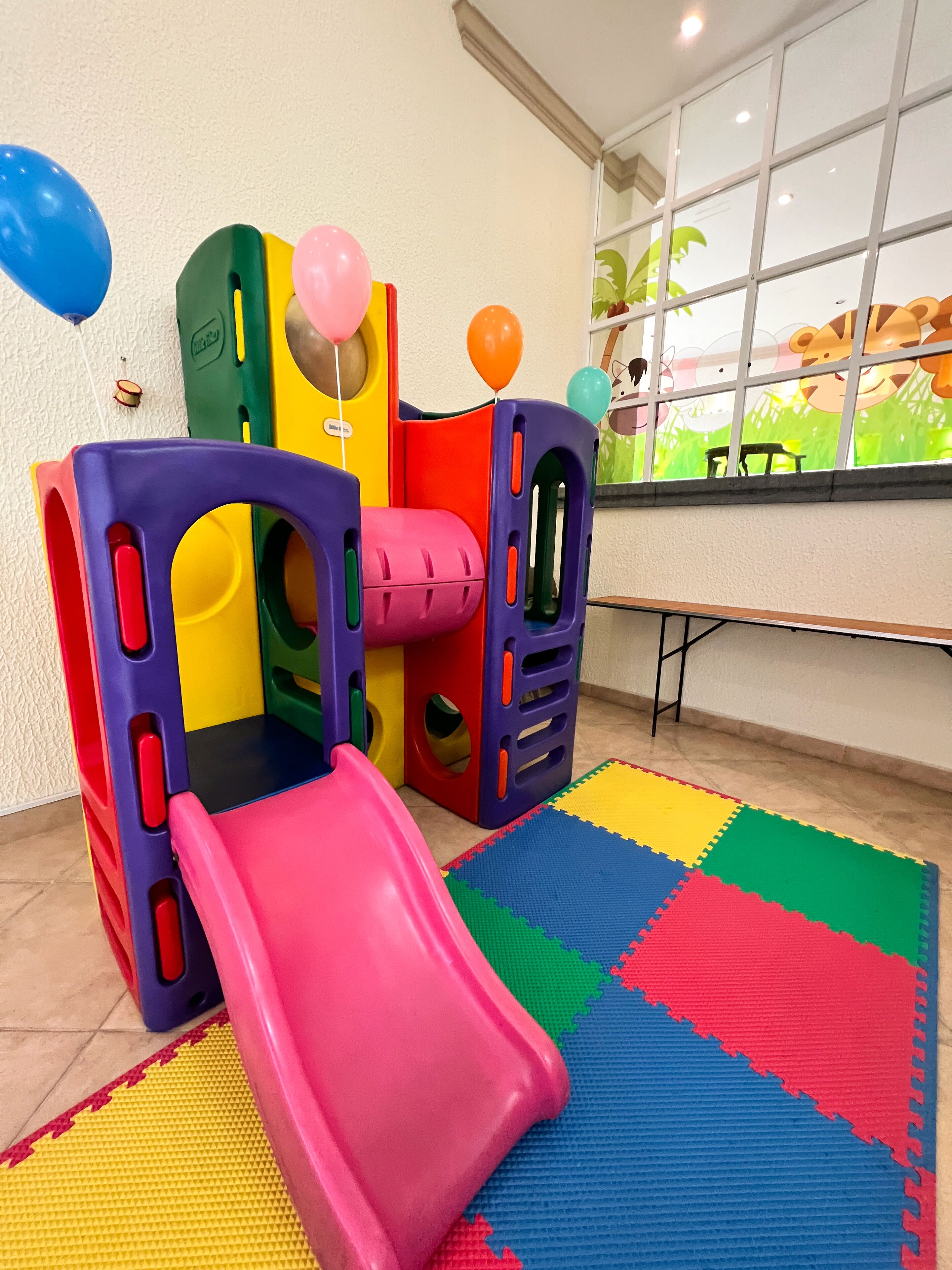 Zona de juegos con un tobogán y estructuras coloridas.