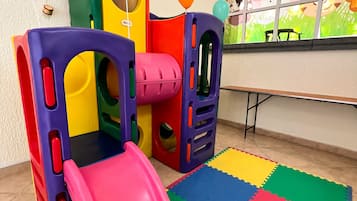 Zona de juegos con un tobogán y estructuras coloridas.