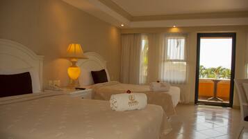 Habitación de hotel con dos camas, una mesita de noche con lámpara, una ventana con cortinas y vistas al exterior.