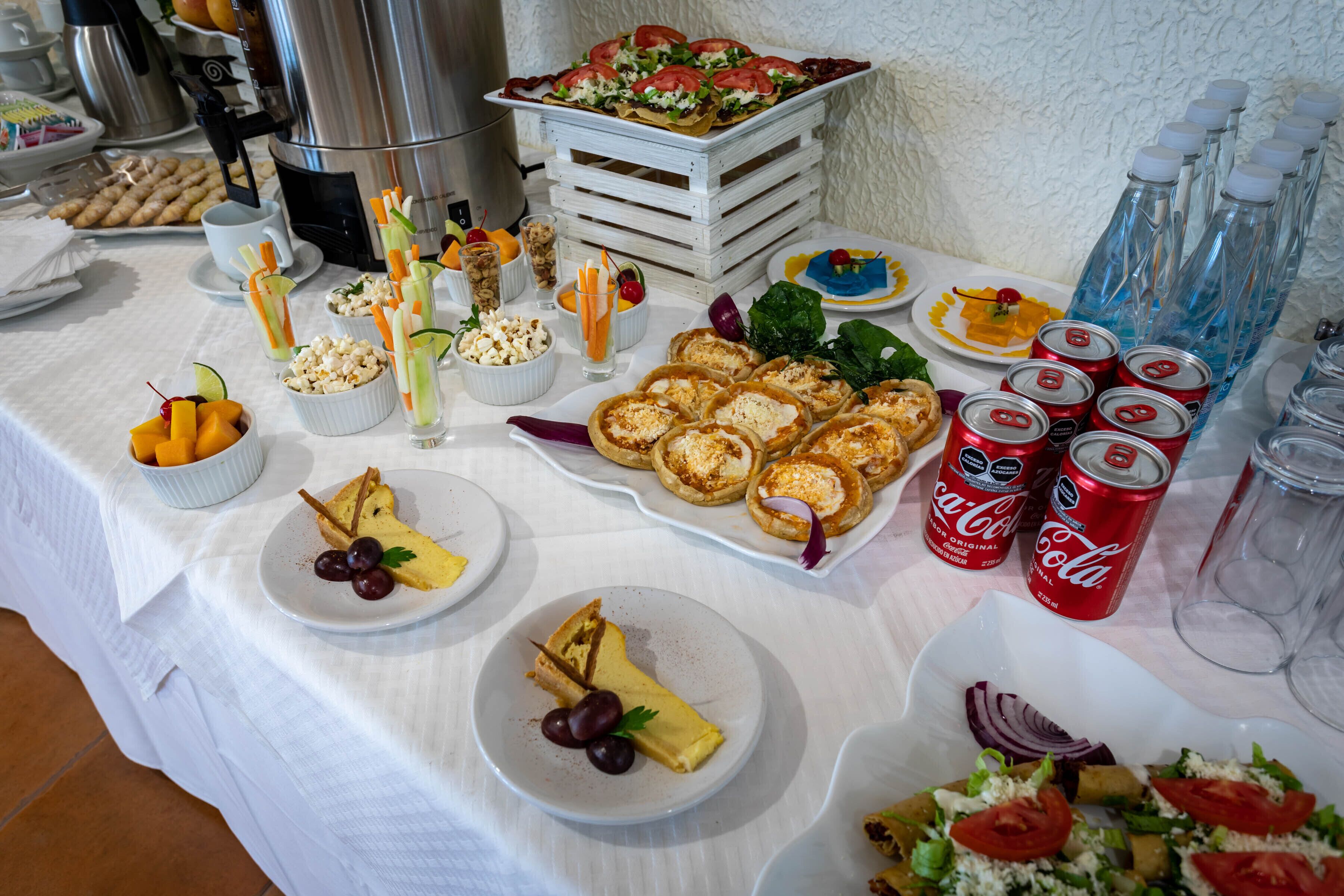 A buffet table with various food items and beverages.