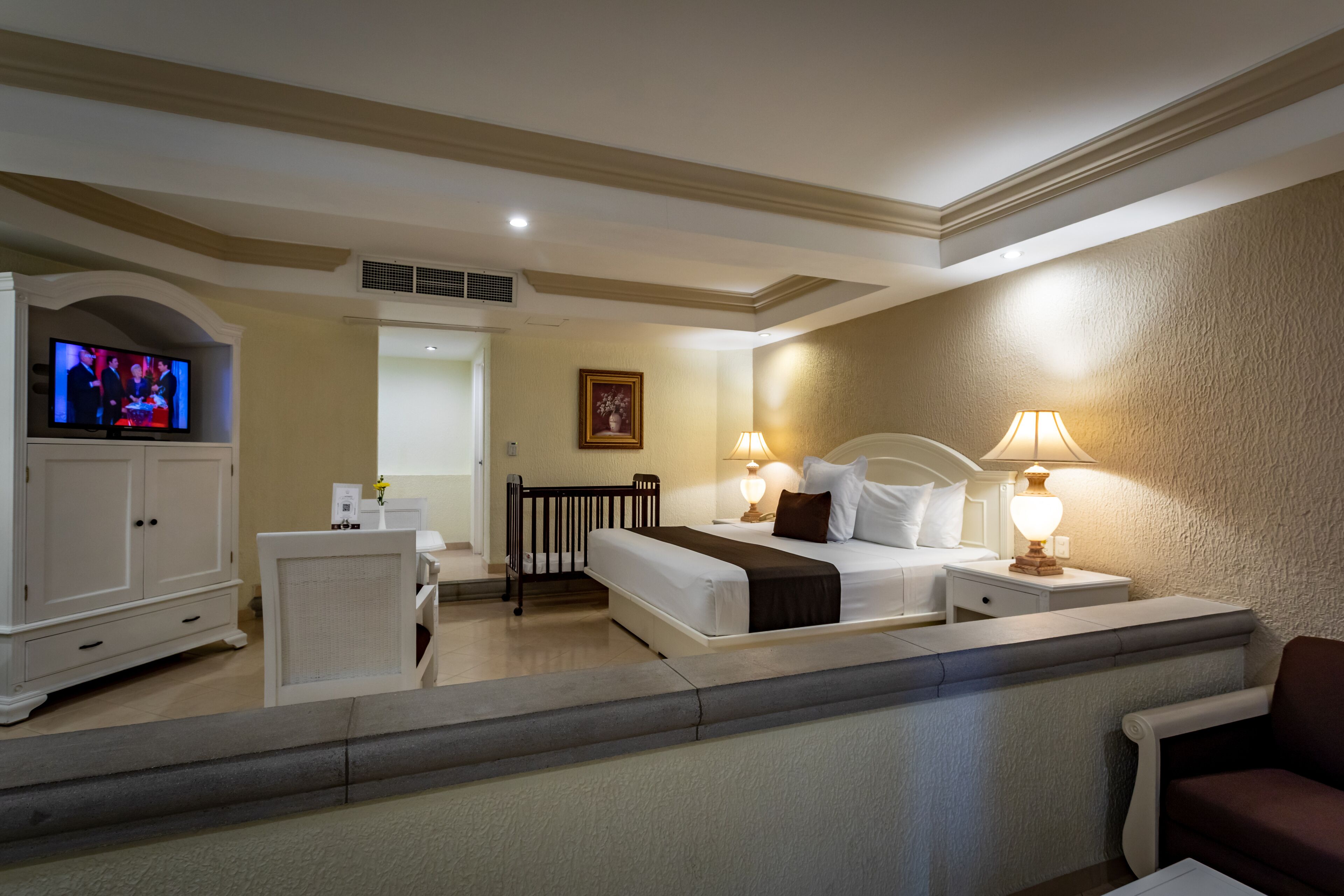 A hotel room with two beds, a TV, a desk, and a chair.