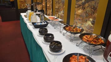 A buffet table with various dishes and beverages.