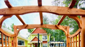A wooden pergola entrance leading to a house with a garden path. - Remington Flats Hotel (Fort Collins)