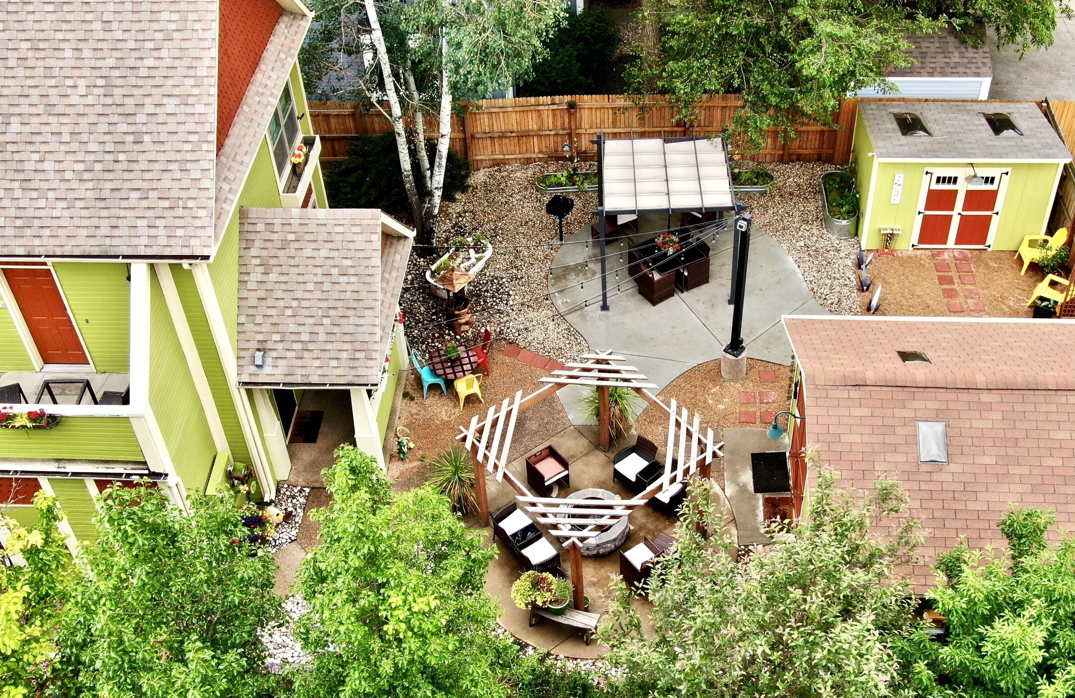 A backyard with a fire pit, outdoor seating, and a small shed.