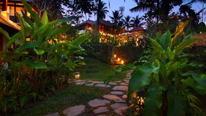 A stone pathway leading to a building surrounded by lush tropical vegetation. - BeingSattvaa Luxury Ubud (Ubud)