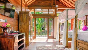 A wooden room with a bed, a wooden cabinet, and a large window. - BeingSattvaa Luxury Ubud (Ubud)