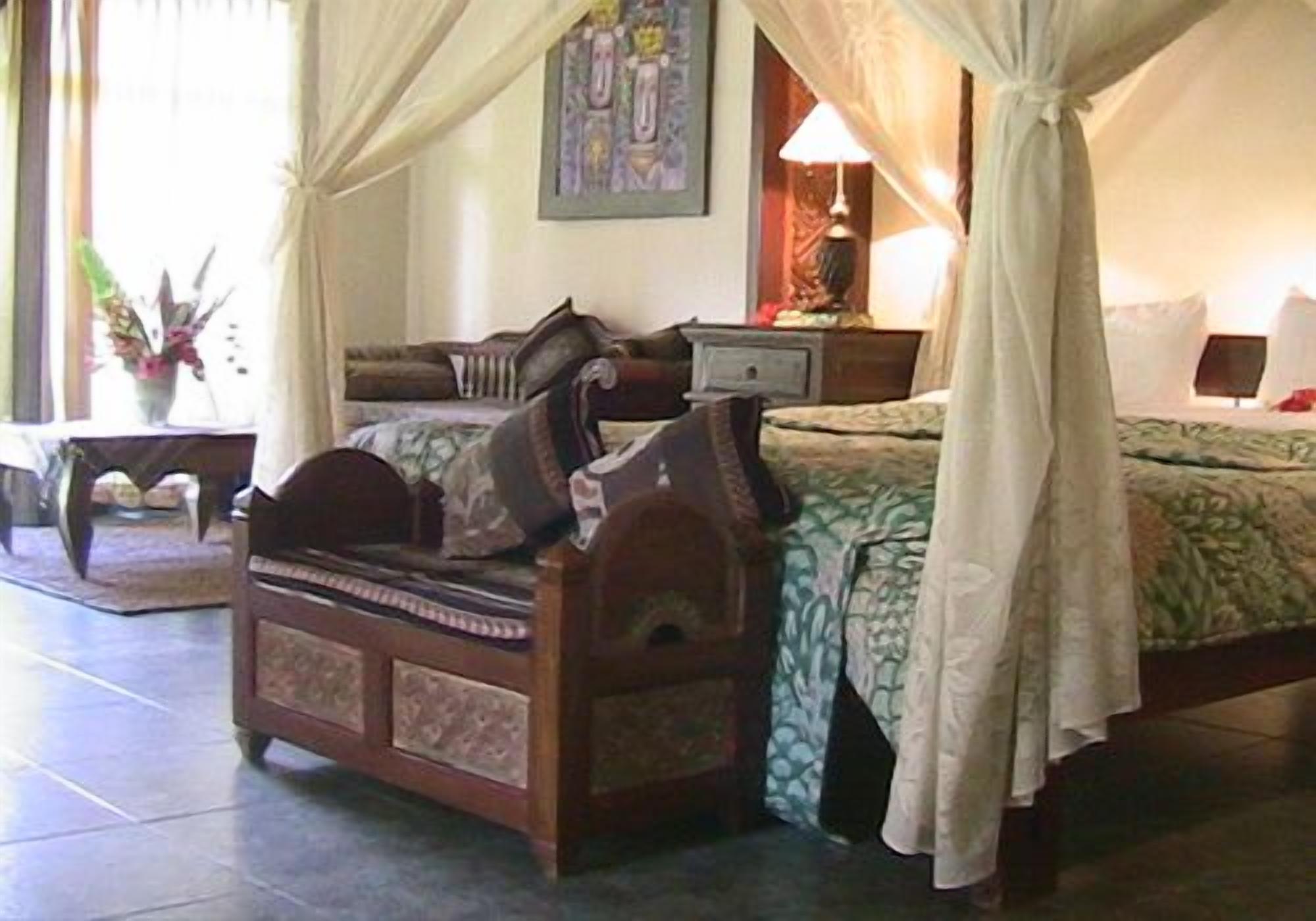 Un dormitorio con una cama de madera, una mesita de noche, una lámpara y un cuadro en la pared.