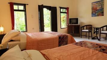 Habitación de hotel con dos camas, televisión, escritorio y sillas.
