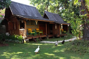 A rustic wooden cabin with a porch and outdoor seating.