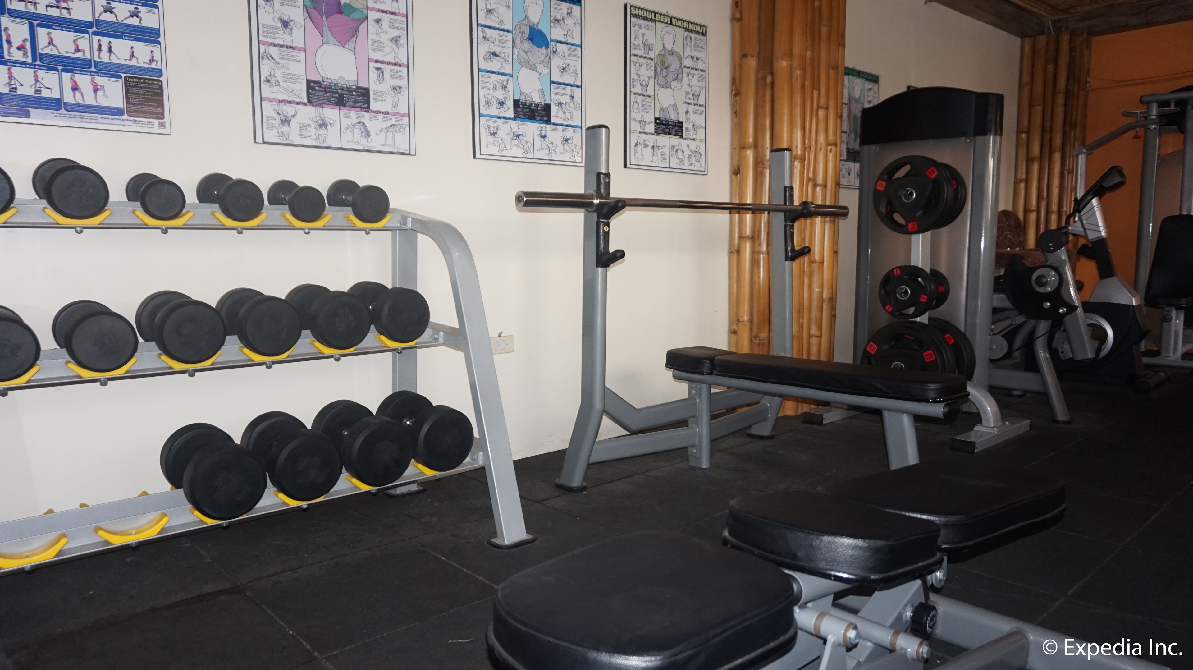 A gym with weight racks, benches, and exercise equipment.