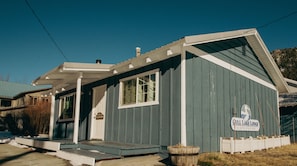A small, single-story building with a porch, a sign indicating it is a guest house, and a wooden fence in front. - Gull Lake Lodge (June Lake)